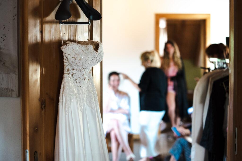 Préparatifs de la mariée en Alsace avec la robe de mariée suspendue et séance maquillage.