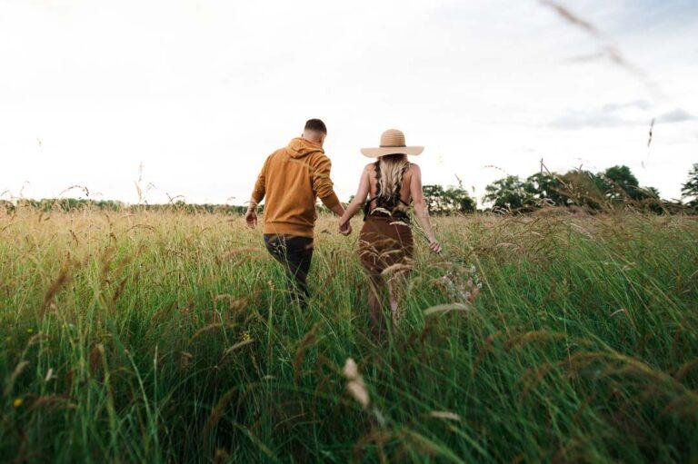 Couple se promenant dans les hautes herbes lors d'une séance photo de couple dans le Bas-Rhin, Alsace.
